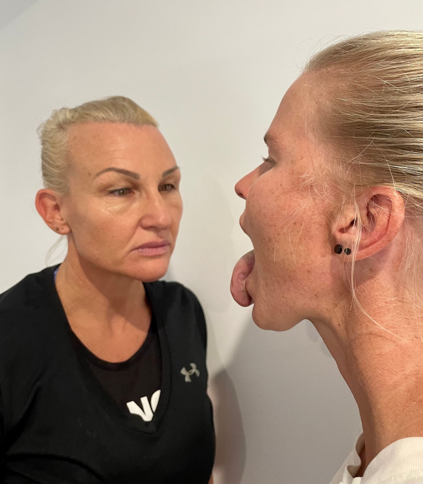 Woman looking at a female's tongue. Traditional Chinese Medicine tongue diagnosis. Analyse a tongue